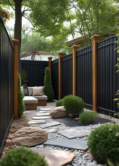 an outdoor garden with gravel, rocks and wooden fenced in area next to trees