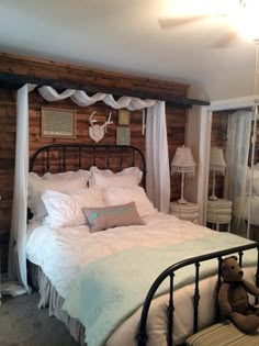 a bed with white sheets and pillows in a bedroom next to a wooden paneled wall