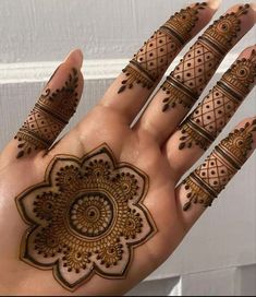 a hand with henna on it that has an intricate design in the middle of it