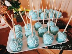 there are many blue candies on the tray and one has white swirled lollipops