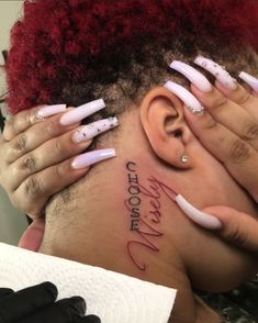 a woman with red hair and white nails has her head covered by fake nails that spell out the word love