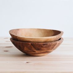 two wooden bowls sitting on top of a table