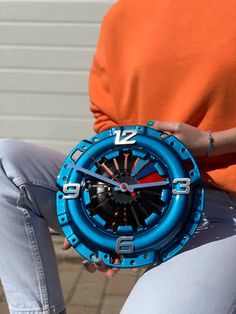 a person holding a blue and black clock