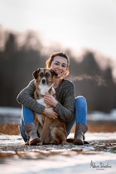 a woman sitting on the ground with her dog