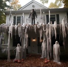 a man standing on top of a house covered in icicles with pumpkins around him