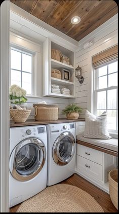 a white washer and dryer in a room with wooden floors, built - in shelving