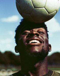 a man balancing a soccer ball on his head