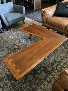 a living room with couches, chairs and a coffee table in the middle of it