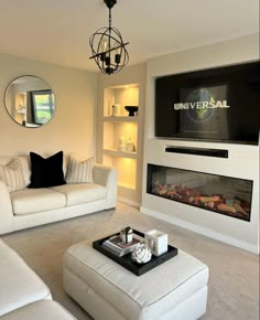 a living room filled with furniture and a flat screen tv mounted on the wall above a fireplace