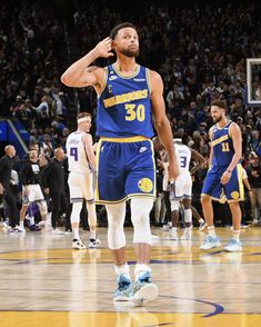 a man standing on top of a basketball court wearing a blue uniform and white socks