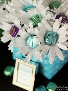 a blue vase filled with white flowers and candy