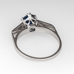 This gorgeous sapphire engagement ring features a 1.56 carat no heat sapphire with Nigeria origin that we sourced and set in an 18k white gold diamond mounting. The top of the shoulders are each accented with a row of three (3), bead set, round single cut diamonds. The ring measures 8.7mm at the top, rises 6.8mm above the finger, tapering to 1.7mm wide and 1.2mm thick at the base of the shank. The ring is currently a size 6.75 and we offer complimentary resizing to fit. Classic Formal Sapphire Ring With Trillion Cut, Trillion Cut Sapphire Ring With Diamond For Formal Occasions, Sapphire Ring With Brilliant Cut For Proposal, Oval Diamond-cut Lab-created Sapphire Ring, Brilliant Cut Sapphire Ring For Proposal, White Gold Trillion Cut Sapphire Ring For Formal Occasions, Formal White Gold Sapphire Ring Trillion Cut, Asscher Cut Sapphire Ring With Diamond Detail, Formal Asscher-cut Lab-created Sapphire Ring