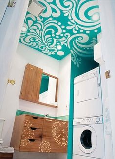 a washer and dryer in a small room with green paint on the ceiling