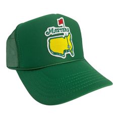 a green trucker hat with the masters logo and yellow golf ball on it's side