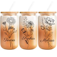 three mason jars with flowers and names on the lids are lined up against a white background