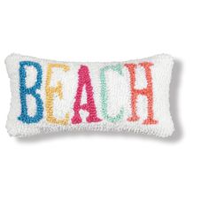 a pillow with the word beach on it in multicolored sequinized letters