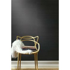 a chair with a white feather on it in front of a black wall and floor