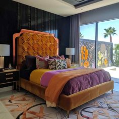 a bedroom with a large bed and lots of pillows on top of it's headboard