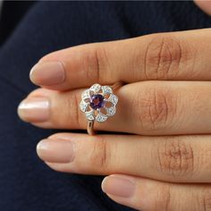 Sometimes when a girl says she likes to receive flowers as a gift, it's not the real flowers she meant. Think twice and go for the safest thing - our Flora ring with amethyst and side Moissanites. Floral jewelry is where it's at! Perfect as a graduation gift, birthday gift, anniversary ring, or a promise ring. Details: Center stone Gemstone: Amethyst Stone Shape: Round Measurements: 5.00mm Side stones Gemstone: Moissanite Shape: Round Measurements: 1.30mm (8) Band measurements: approx. 1.8mm wid Flowers As A Gift, Receive Flowers, A Promise Ring, Amethyst Ring Engagement, Floral Jewelry, Floral Jewellery, She Likes, Amethyst Stone, Anniversary Ring