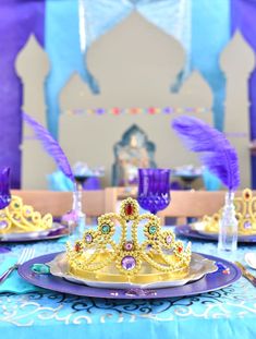 there is a purple and gold crown on the table set for a princess birthday party