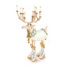 a white and gold reindeer figurine with four candles