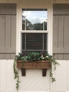 a window box with plants in it on the side of a house