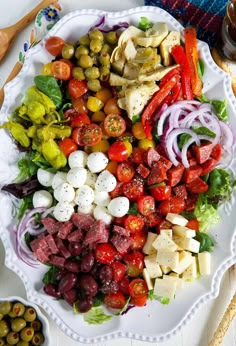 a white plate topped with lots of different types of salads and meat on top of lettuce