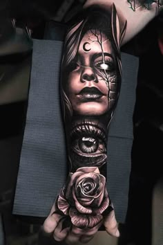 a woman's arm with tattoos on it and roses in her hand, as if she