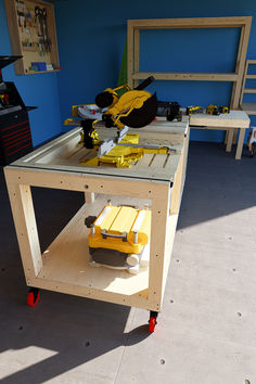 a workbench made out of plywood with tools on the table and chairs in the background