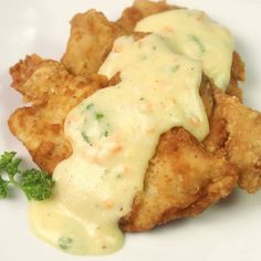 chicken with gravy and broccoli on a white plate