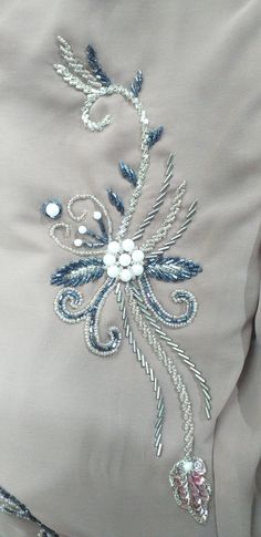 the back of a woman's dress with beading on it