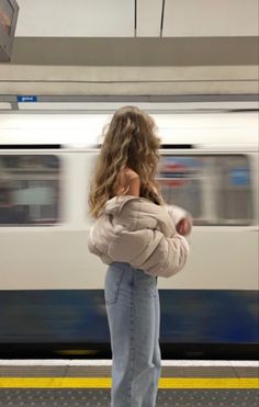 a woman standing in front of a train