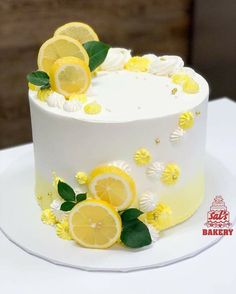 a white cake with lemons and flowers on it