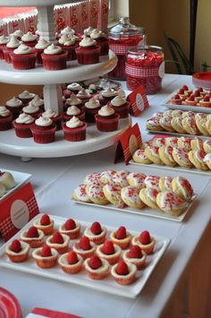 a table filled with lots of cupcakes and cakes on top of trays