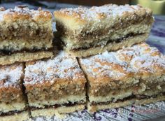 several pieces of cake are stacked on top of each other with powdered sugar toppings