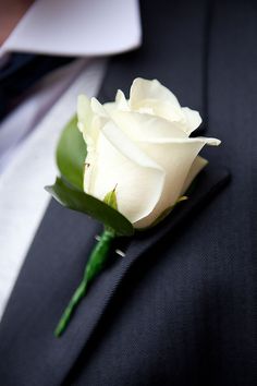 a white rose is placed on the lapel of a man