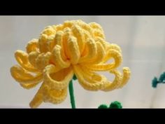 a crocheted yellow flower sitting on top of a table