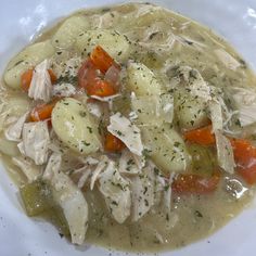 a white bowl filled with chicken and vegetable soup