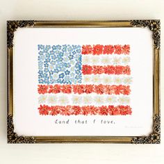 an american flag with the words land that i love written in red, white and blue flowers