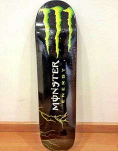 a skateboard with the words monster energy on it's side and lightning in the background