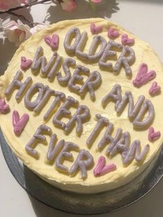 a cake that is decorated with letters and hearts on it, sitting on a table