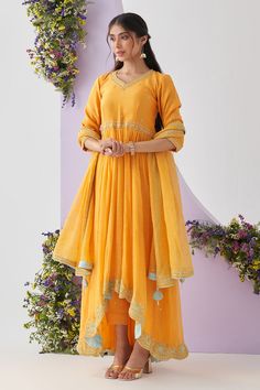 Yellow anarkali with metallic thread, sequin, resham and pearl embroidery in floral placement pattern and scallop border. Paired with chanderi pant and dupatta.
Components: 3
Pattern: Embroidery
Type Of Work: Metallic thread, sequin, resham, pearl, floral
Neckline: Leaf neck
Sleeve Type: Three quarter
Fabric: Anarkali: Chanderi Mul, Pant: Cotton, Dupatta: Mul Chanderi
Color: Yellow
Other Details: 
Scallop border
Tassel bordered sheer dupatta
Back tassel tie-up
Occasion: Mehendi and Haldi - Aza F Semi-stitched Gota Work Palazzo Set In Anarkali Style, Unstitched Gota Work Anarkali Set, Festive Chinon Anarkali Set With Chikankari Embroidery, Maxi Length Salwar Kameez With Gota Work In Chanderi, Anarkali Palazzo Set With Zari Work, Transitional Anarkali Set With Gota Work, Maxi Length Chanderi Salwar Kameez With Gota Work, Unstitched Maxi Length Anarkali Set With Gota Work, Diwali Anarkali Set With Gota Work In Chinon