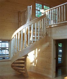 a spiral staircase in a house with wood paneling