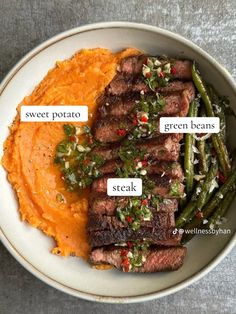 a white plate topped with steak and mashed potatoes next to green beans on top of mashed potatoes