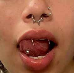 a woman with piercings on her nose and tongue