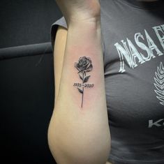 a woman's arm with a rose tattoo on the left side of her arm