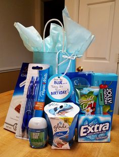 a blue bag filled with lots of items on top of a wooden table