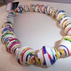 a multicolored necklace is displayed on a table