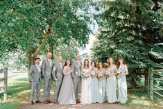 a group of people standing next to each other in front of trees and fenced area