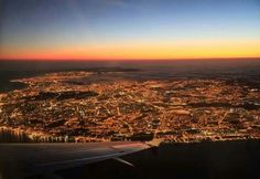 an aerial view of the city lights at night taken from an airplane window with no one in it